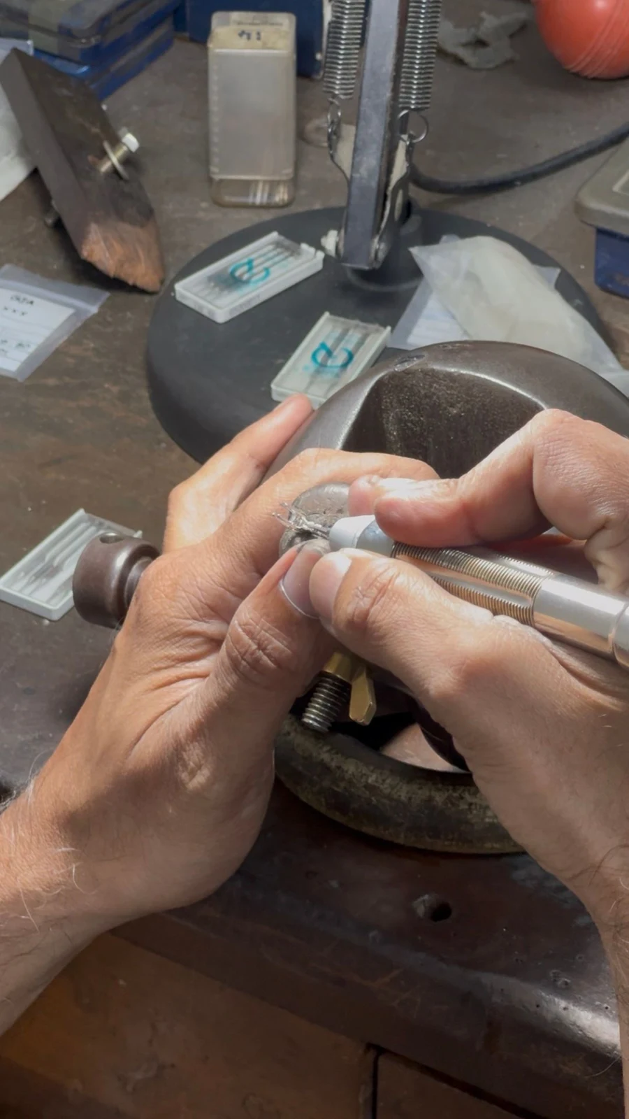 A craftsman working on a jewellery piece with a handheld tool