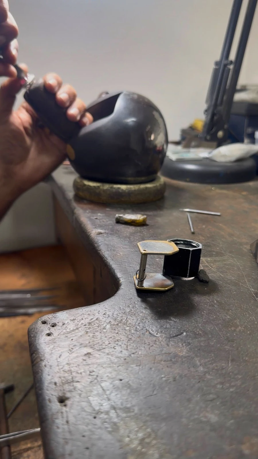 A craftsman using a hand torch at the jewellery bench
